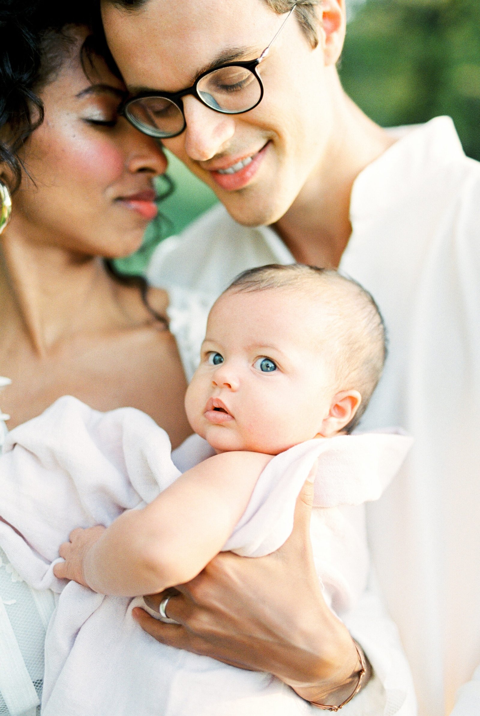 Man hugs a woman with a baby. Portrait
